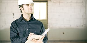 Un travailleur inspecte un bâtiment en prenant des notes